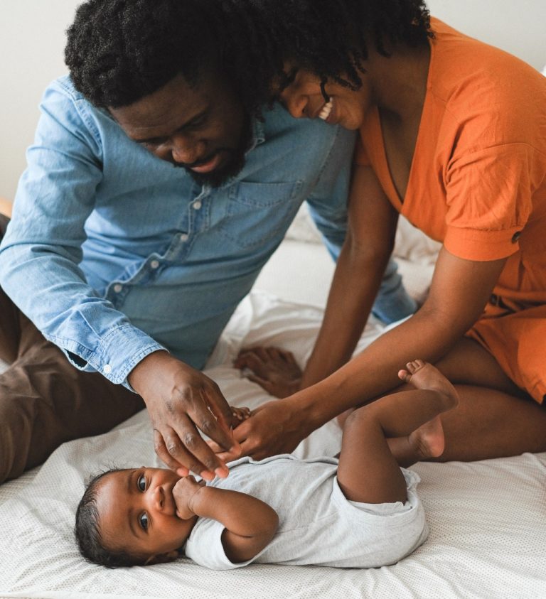 Black mother and father admiring their healthy baby