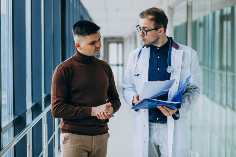 Doctor talking with his patient at clinic Cardiac Arrest vs. Heart Attack signs, causes, and risk factors can mean the difference between life and death.